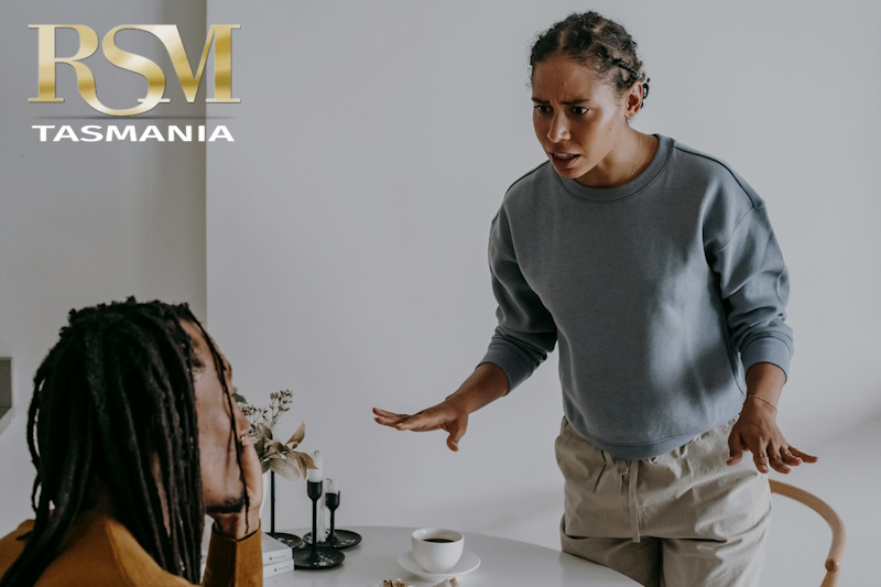 Small business owner facing an upset customer pointing blame, highlighting tension and potential liability claim.